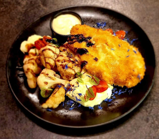 Chicken chop in panko breadcrumbs, with cauliflower fried in garlic butter, mashed potatoes and cheese sauce