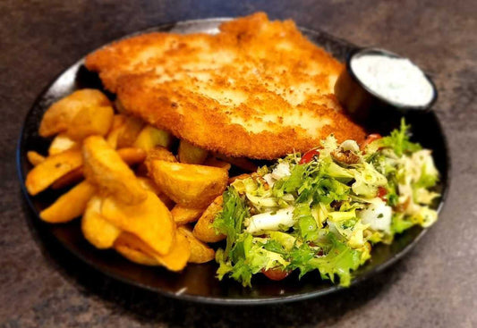 Chicken schnitzel with potato wedges and green salad
