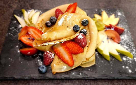 Thin pancakes with maple syrup and fruit